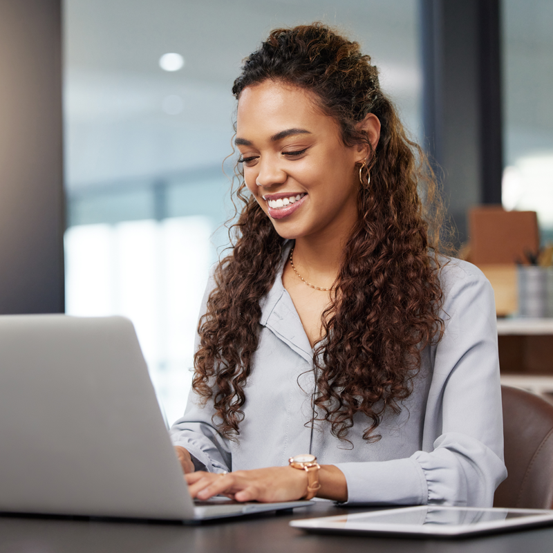 a business women typing on a computer at a desk