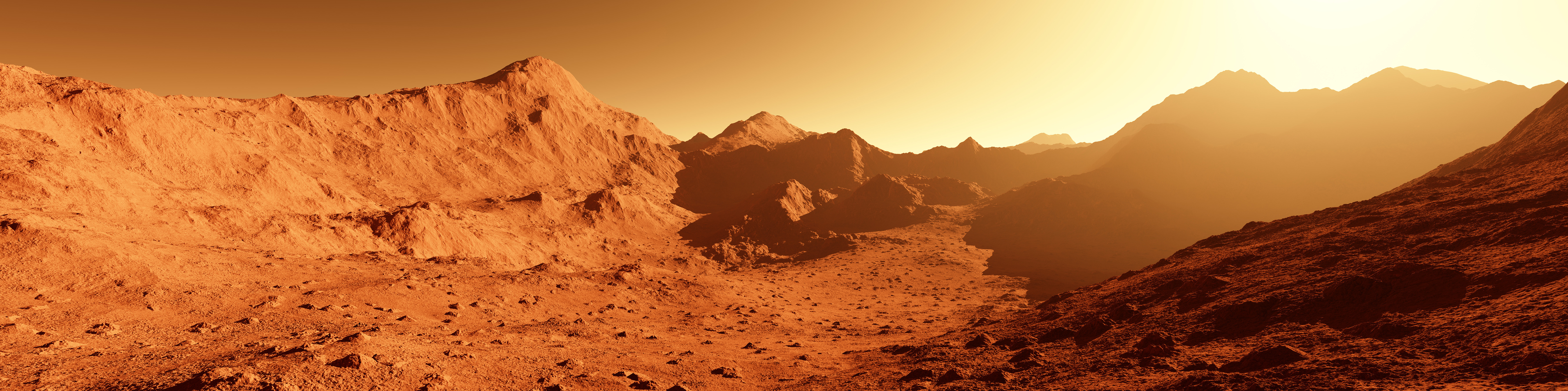 Panoramic view of the Martian surface featuring rocky, red-orange terrain, rugged mountains, and a valley stretching into the distance beneath a hazy sky.