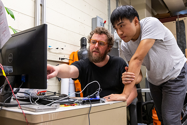 Two stedents examining data on their computer collected from a research experiment at Georgia Tech.