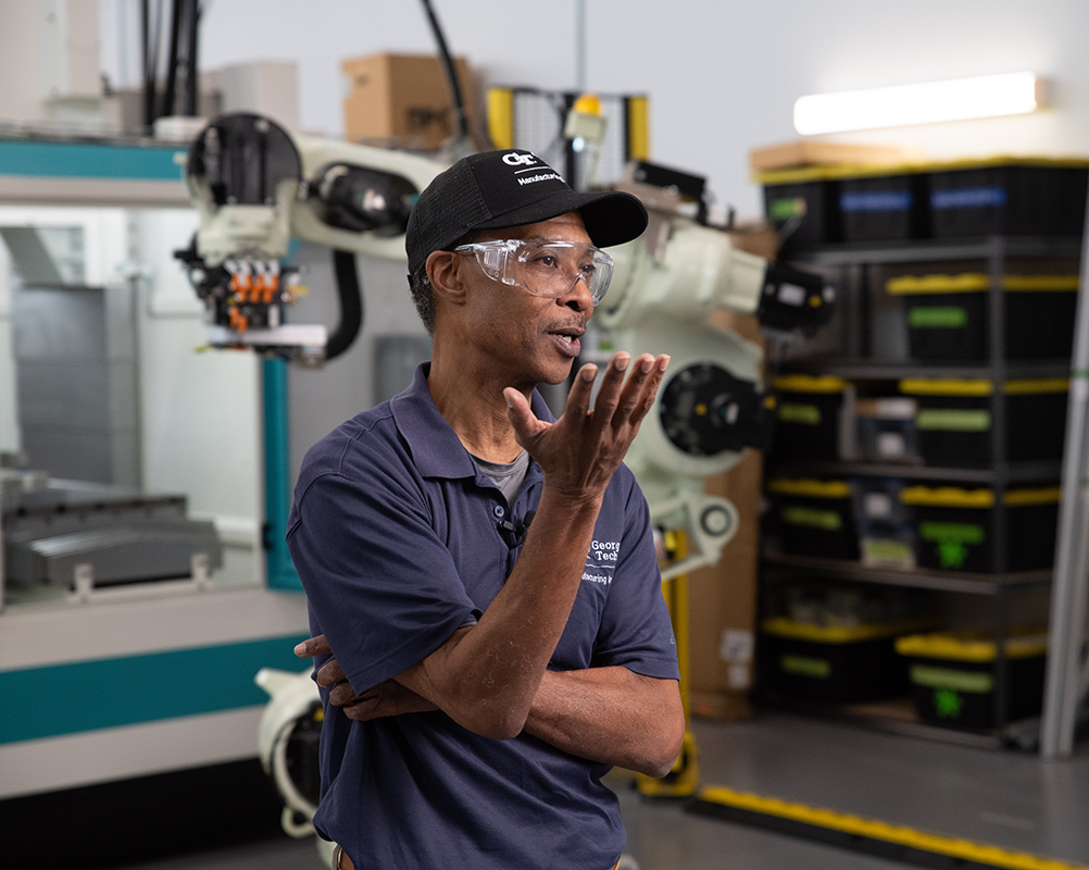 male researcher speaking and gesturing with his hands in a lab at Georgia Tech