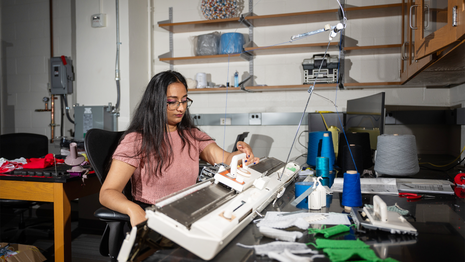 Krishma Singal operates a knitting machine in a research lab at Georgia Tech