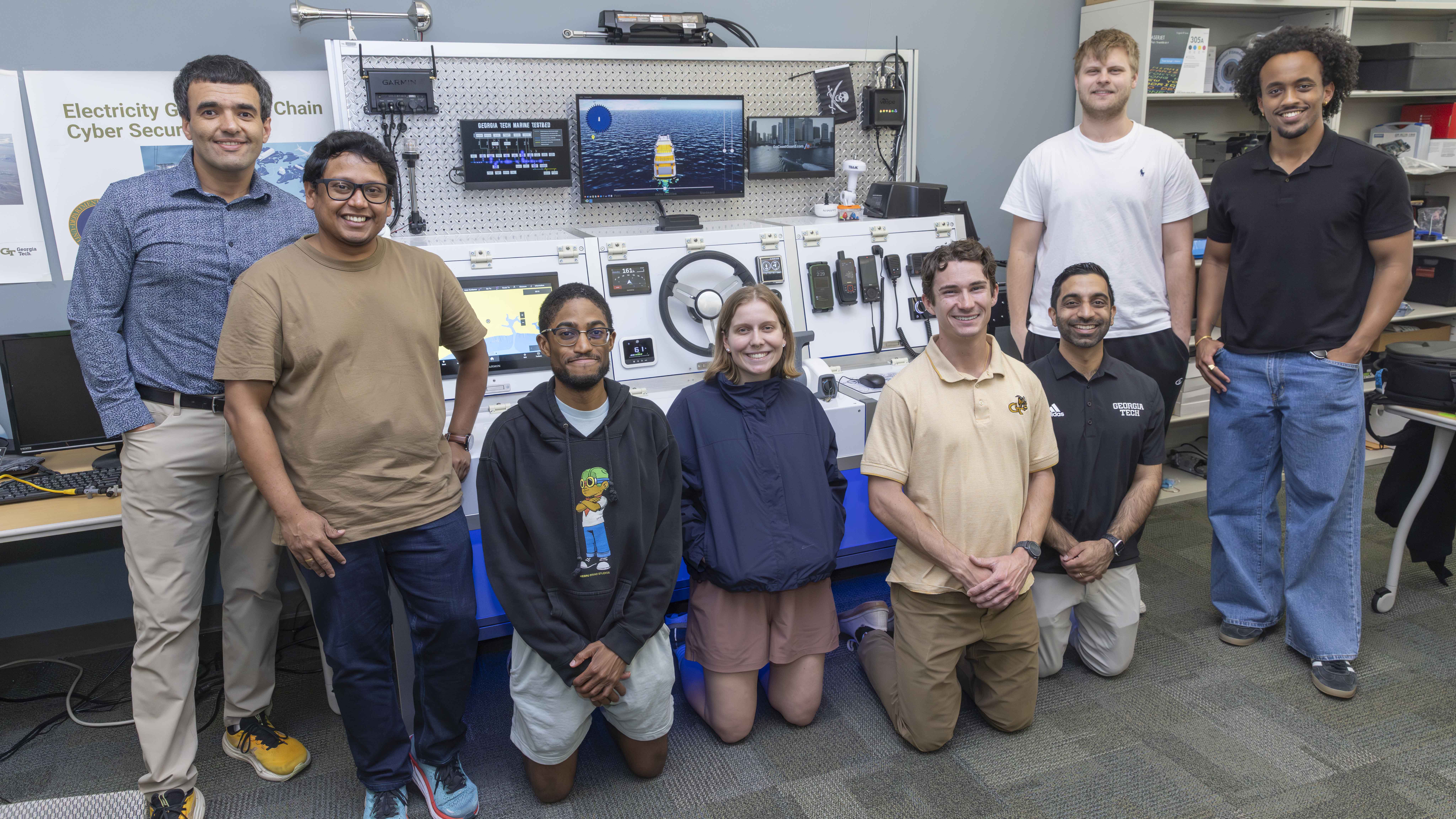 A group photo of students and faculty standing around lab equipment found on a ship. 