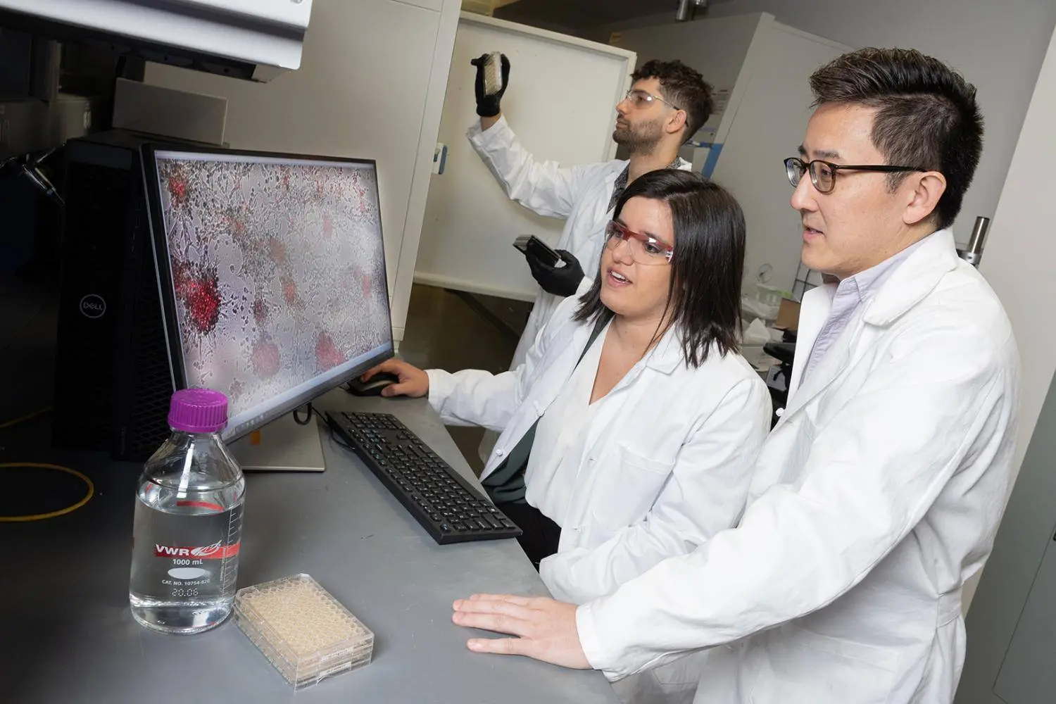 Three Georgia Tech researchers working together in the lab on cancer research