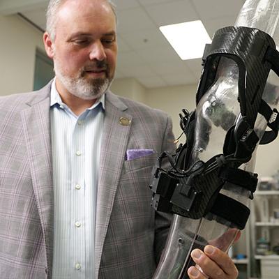 Omer Inan holds an early prototype of Arthroba.