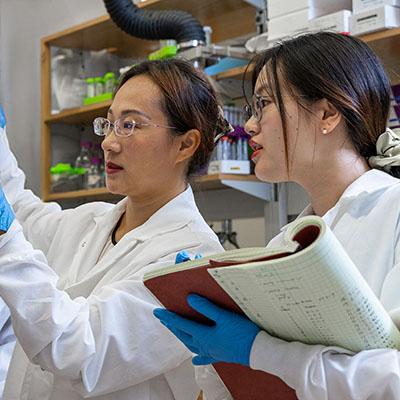 two female researchers in a Georgia Tech lab wearing white coats
