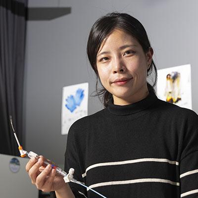 female researcher holds a sensor in a research lab at Georgia Tech
