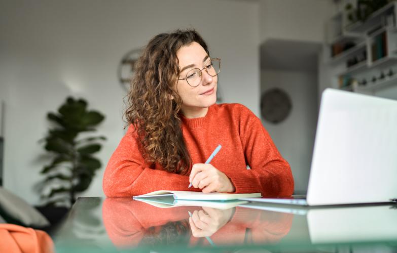 woman taking notes during class 