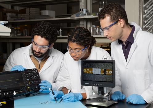 Ramy Ghanim, Joy Jackson, and Alex Abramson test a tiny implantable device in the lab.