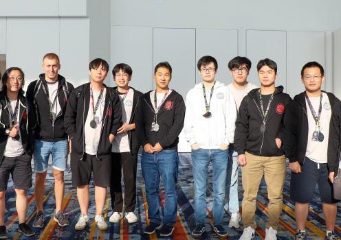A group of people standing inside of a convention hall. 