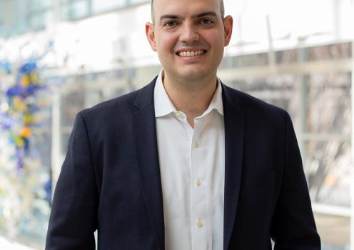 Andre Calmon, associate professor of operations management, smiles wearing a dark suit jacket and white collared shirt.