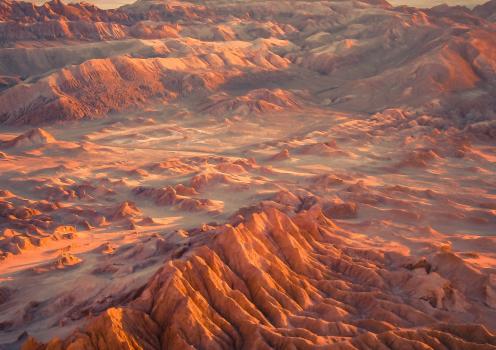 A landscape of red mountains and valleys in the arid Atacama Desert.