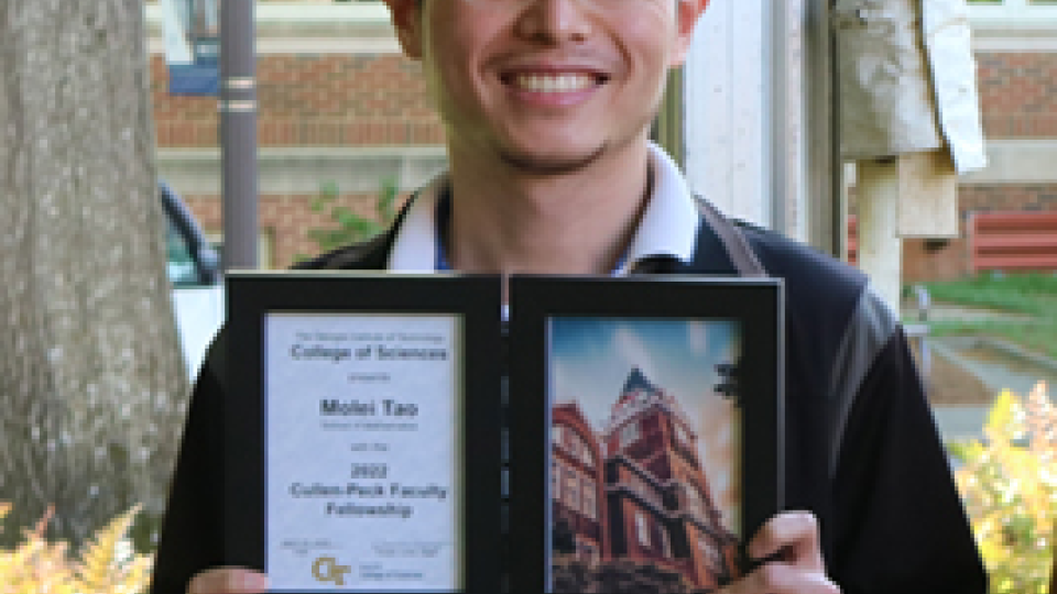 Photo of Molei Tao holding his College of Sciences Faculty Development Award during the 2022 Spring Sciences Celebration.