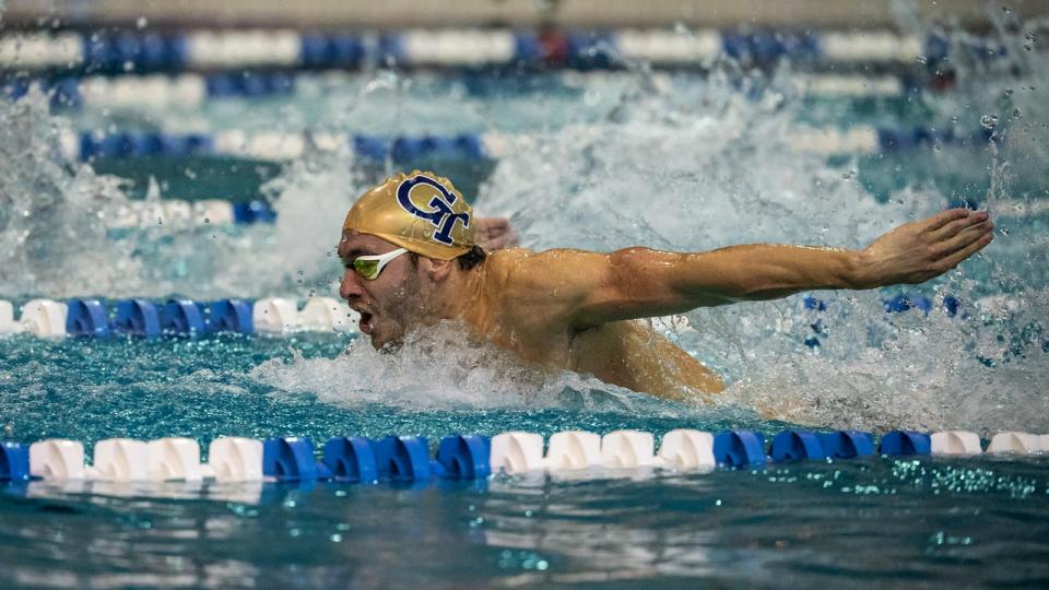 A swimmer wearing a GT swim cap in mid stroke in the Georgia Tech pool