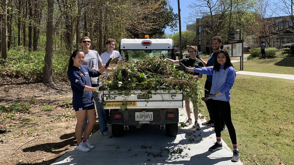 Students remove ivy from an area near The Kendeda Building for Innovative Sustainable Design in April 2022.