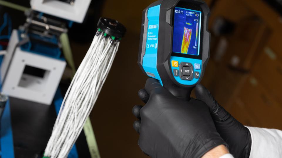 A thermal imaging device shows heat distribution in the carbon fibers.