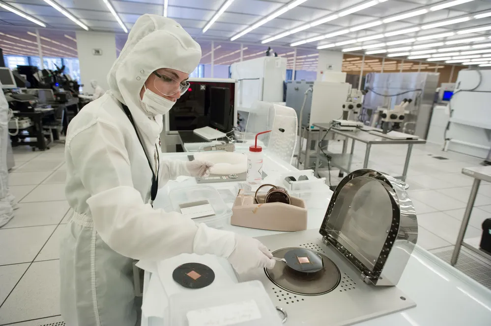 A scientist dressed in protective clothing works in a clean room laboratory at Georgia Tech