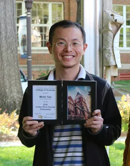 Photo of Molei Tao holding his College of Sciences Faculty Development Award during the 2022 Spring Sciences Celebration.