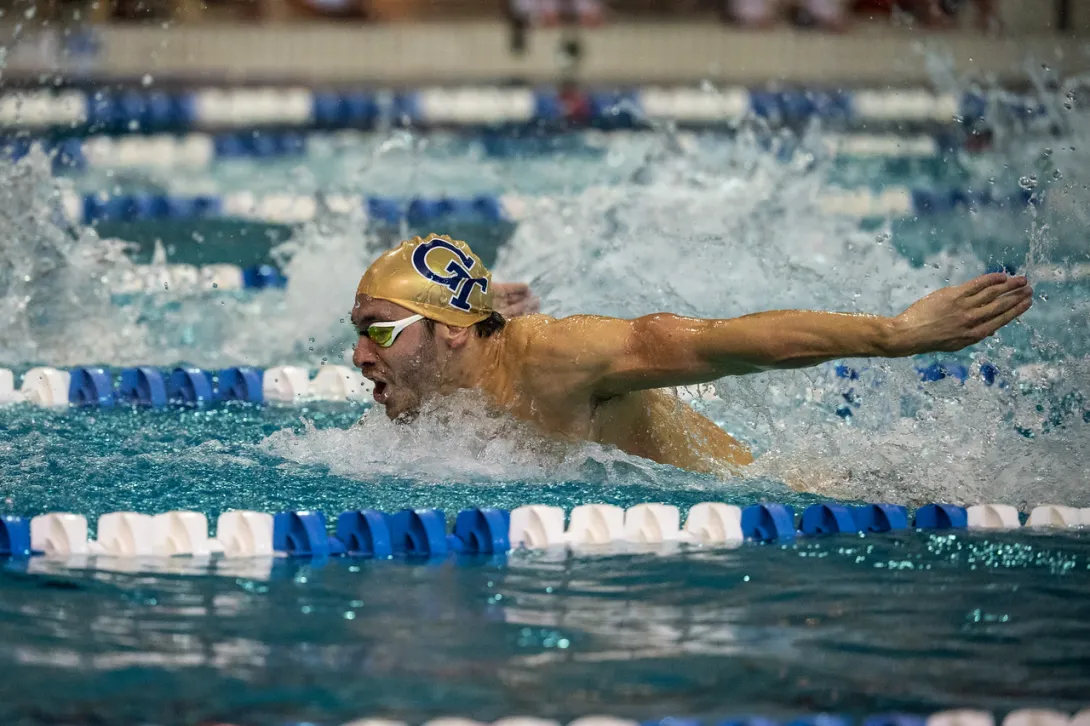 A swimmer wearing a GT swim cap in mid stroke in the Georgia Tech pool