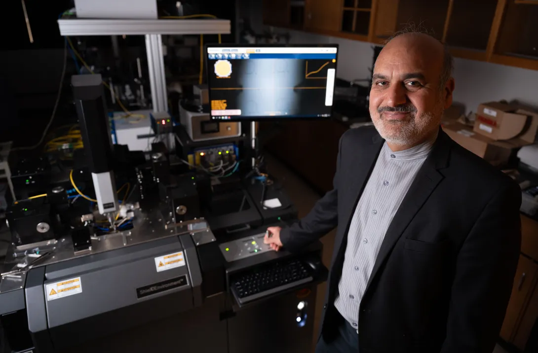 Professor Ali Adibi in front of testing equipment for his 3D optical routing system.
