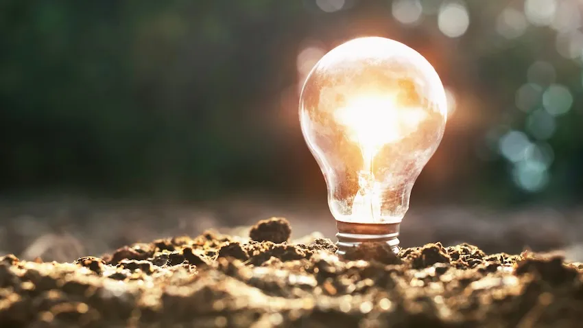 An Adobe stock conceptual image of a lighted bulb in the dirt illustrating new technology that draws energy from dirt.