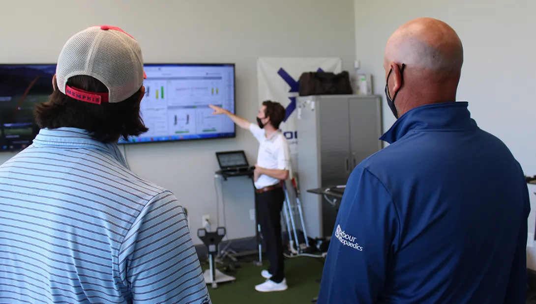 Second-year mechanical engineering student Brittan Pero talks through some of the data collected during tests of a 3D-printed putter with Tech alumni Reagan Cink, left, and his father, Stewart, a PGA Tour pro golfer. (Photo: Joshua Stewart)