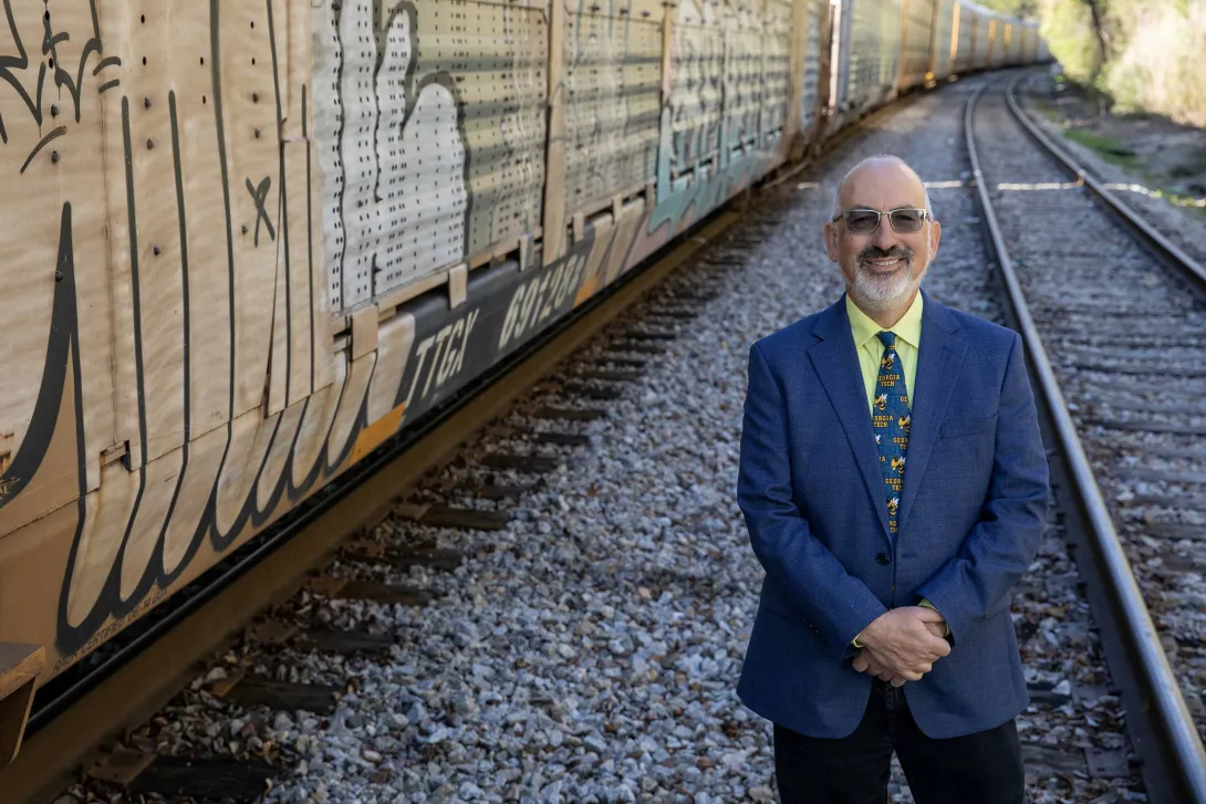 Railroads are key components of the nation’s critical infrastructure. Jeremy Epstein poses with rail cars on a siding. (Credit: Sean McNeil, GTRI)