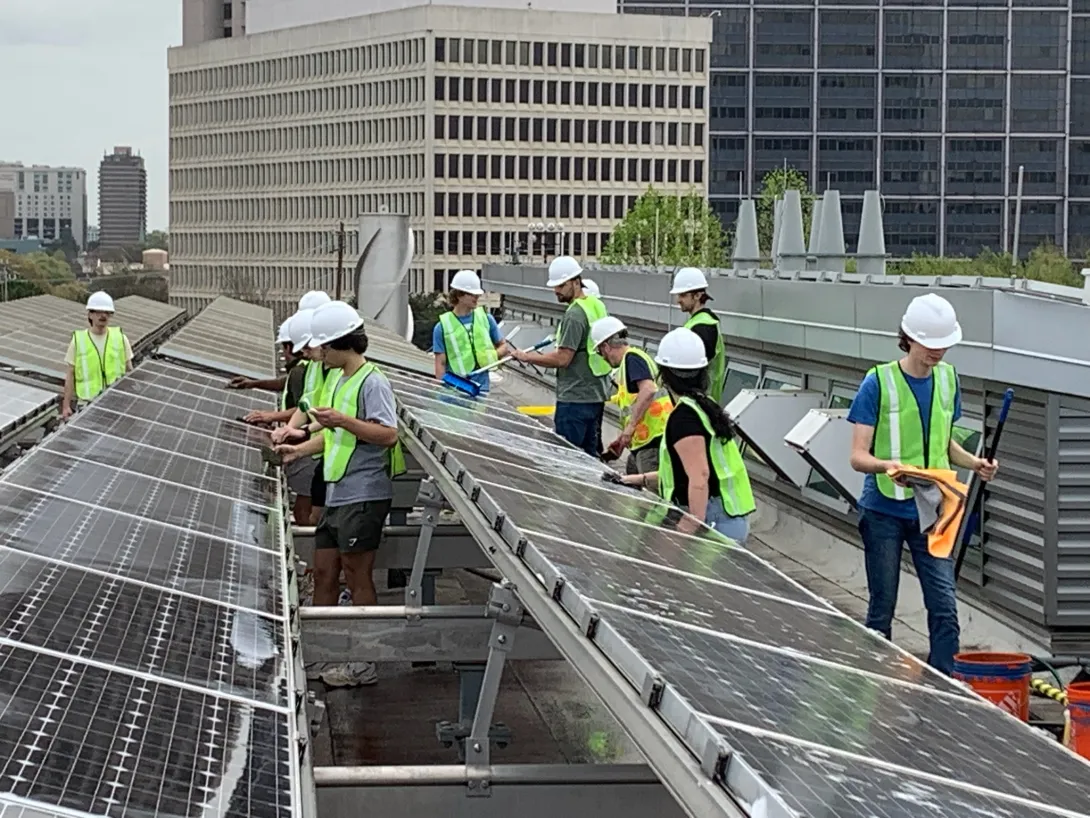 Student volunteers busy at work cleaning the solar panels