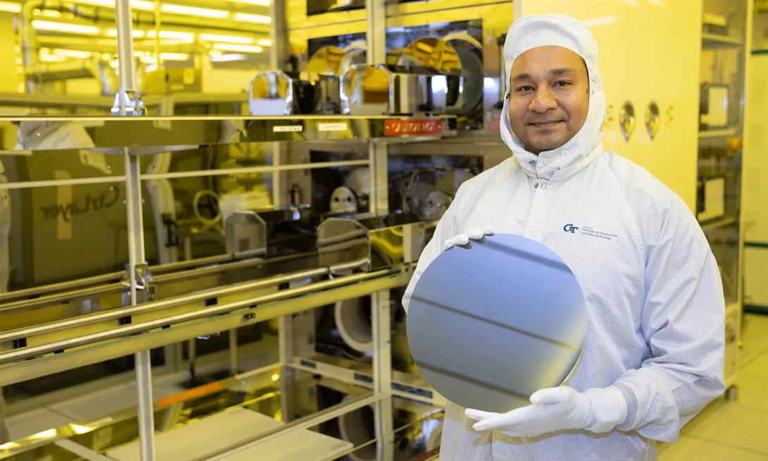 Asif Khan holds a silicon wafer in a cleanroom.