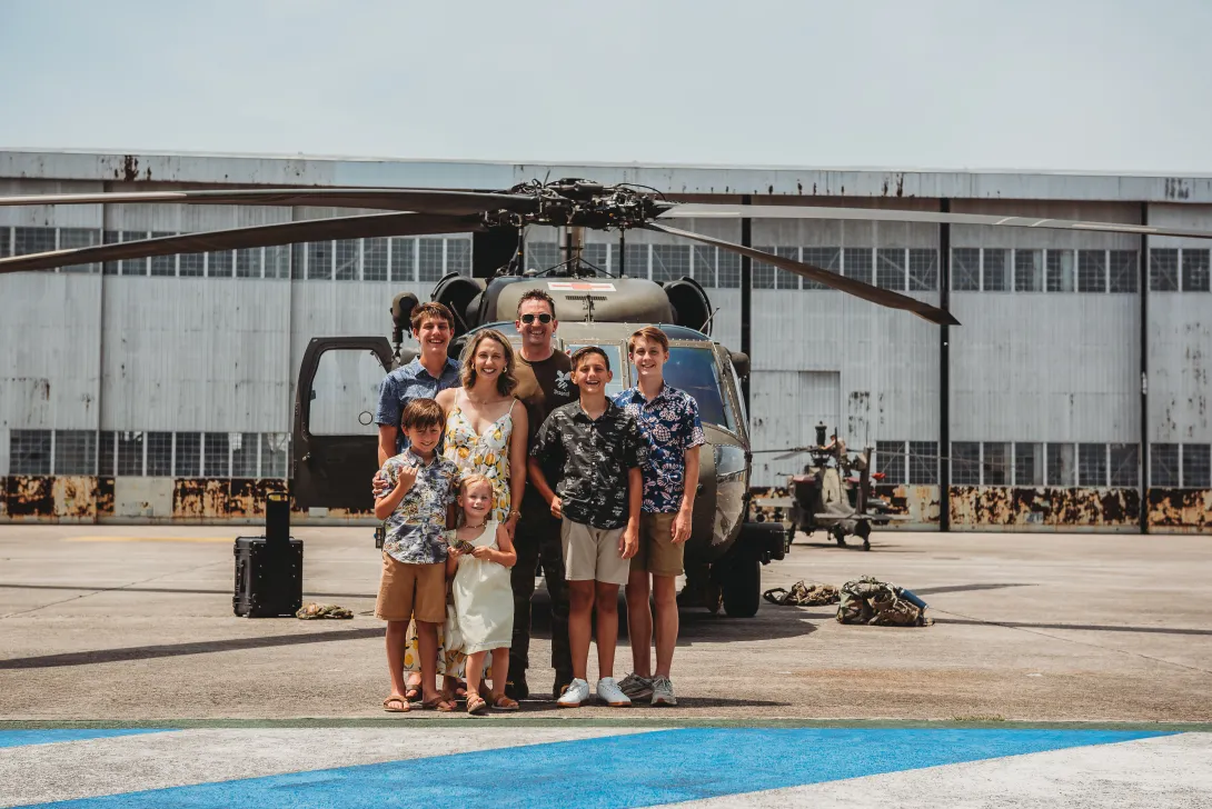 Berg and his family stand next to the model of helicopter frequently flown during his career.