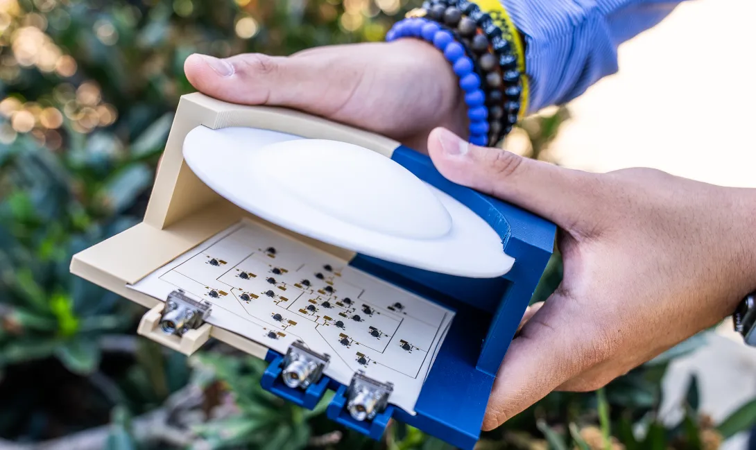 A close‑up view of the device displays an array of tiny antenna elements positioned behind the lens, each modulating reflected wireless signals to enable high‑speed communication with minimal energy use.