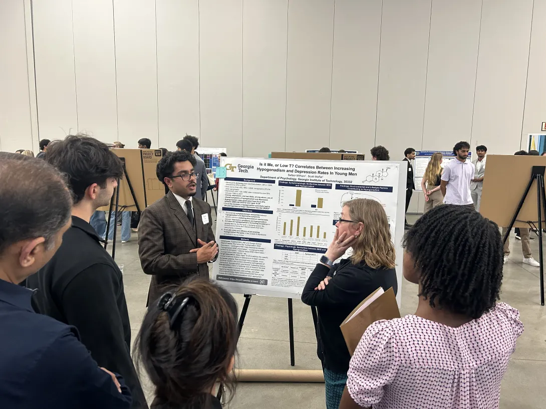 A group of students and faculty is discussing a poster during the first poster session.