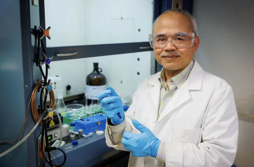 Photo of Rallming Yang in a lab holding a syringe 