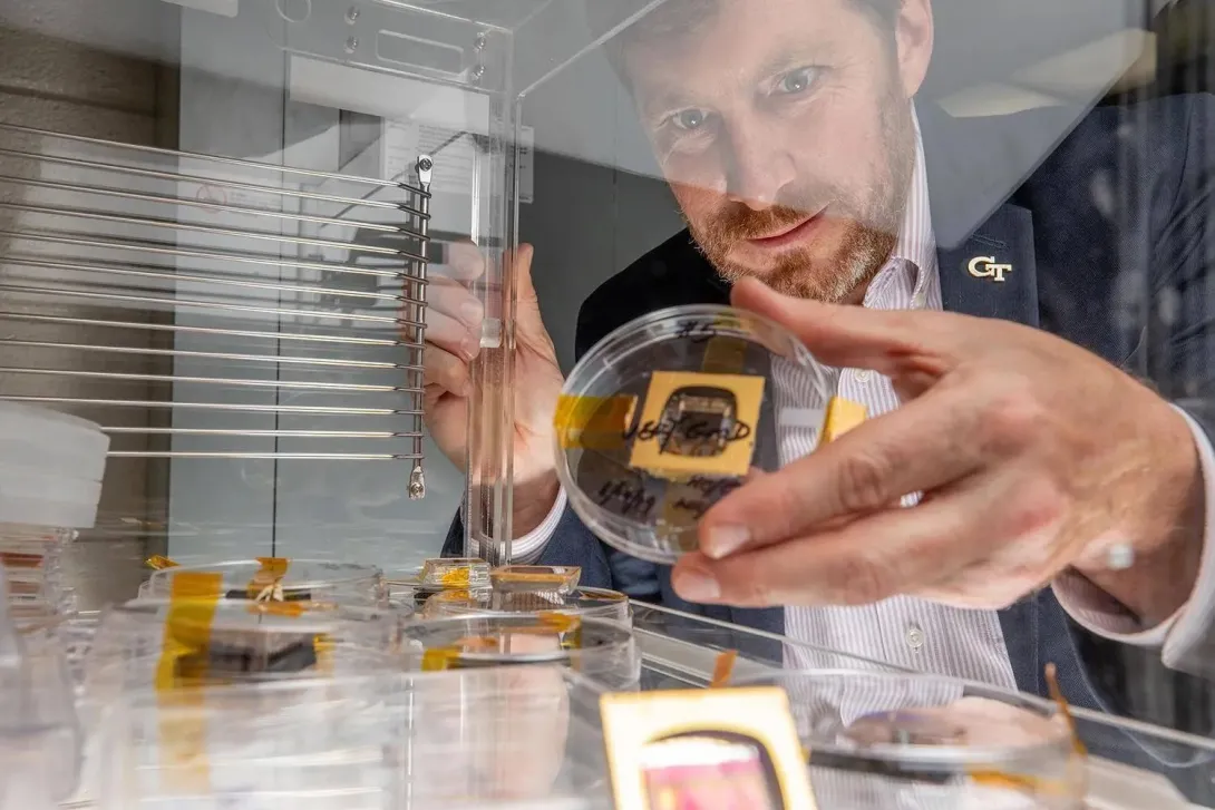 Jud Ready holds a sample of a perovskite solar cell, along with other samples similar to those launched to the International Space Station. (Photo: Branden Camp)