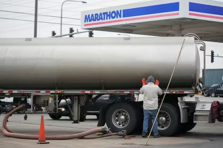 A tanker truck delivers fuel to a gas station. AP Photo/Erin Hooley