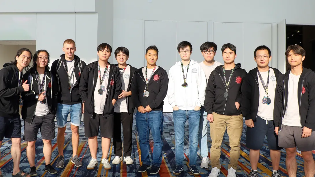 A group of people standing inside of a convention hall. 