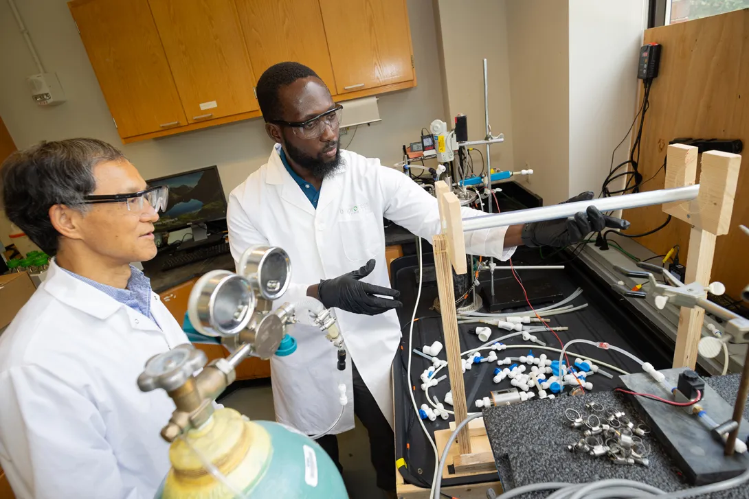 Ahmed Yunus and Yongsheng Chen working with a wastewater reactor system in the lab.