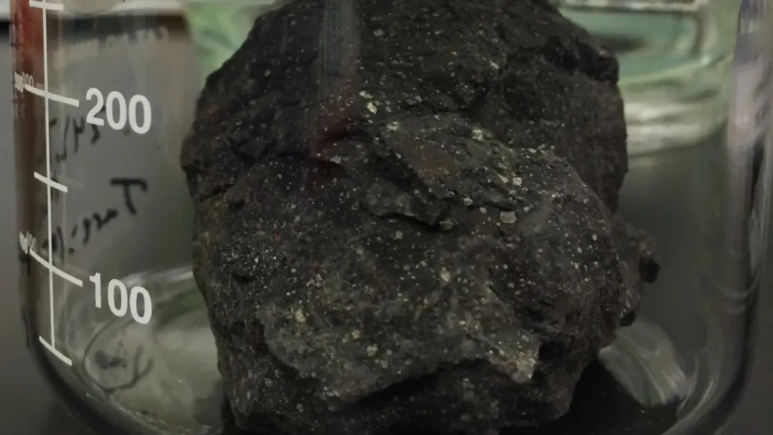 A piece of meteorite inside a glass jar.